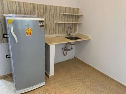 a small kitchen with a sink and a refrigerator at Red sea Hotel Marsa Alam in Marsa Alam City