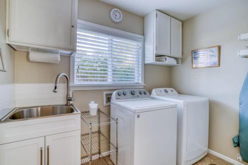 a kitchen with a sink and a washer and dryer at Captains Quarters in Lincoln City