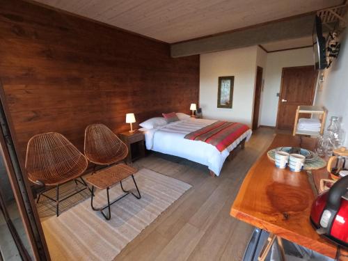 a bedroom with a bed and a table and chairs at Esfera Pichilemu - Lodge in Pichilemu