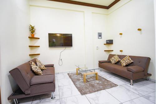 a living room with two couches and a tv at Hotel Diamante in Santa Cruz Huatulco