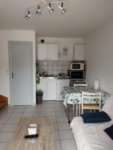 un salon avec une cuisine et une table dans l'établissement Le petit chez nous, à Trégueux