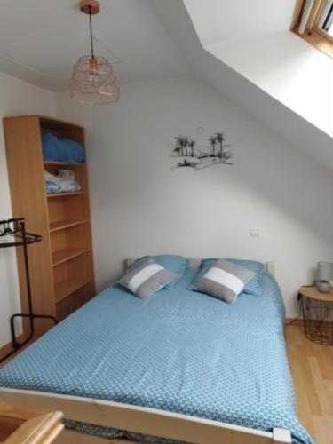 - une chambre avec un lit bleu dans l'établissement Le petit chez nous, à Trégueux