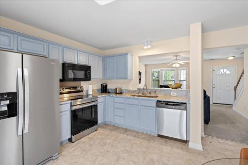 a kitchen with blue cabinets and white appliances at Exquisite E Charlotte house in Charlotte