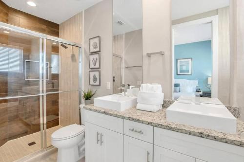 a bathroom with two sinks and a shower and a toilet at New Awesome decorated dreamhouse in Orlando