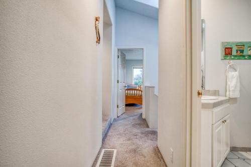 a hallway of a bathroom with a sink and a mirror at Sea-Renity in Lincoln City