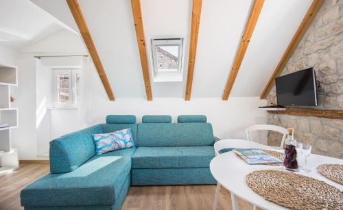 uma sala de estar com um sofá azul e uma mesa em Tragos Lemon Tree em Trogir
