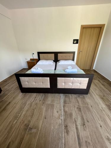 a bed in a room with a wooden floor at Progon House in Tepelenë