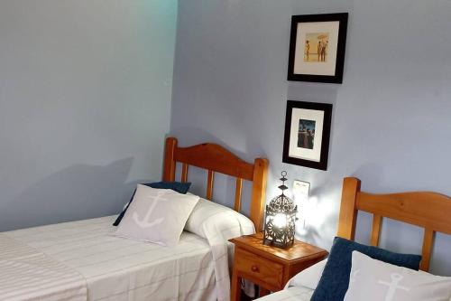 een slaapkamer met 2 bedden en een tafel met een nachtkastje bij Espuma de Sal in Mazo