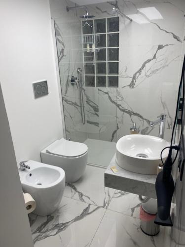 een badkamer met een toilet, een wastafel en een douche bij Holiday House Fifteen in Catania