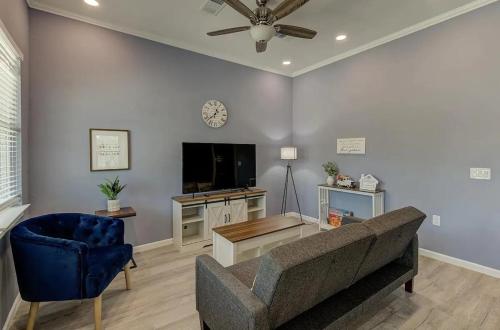 a living room with a couch and a tv at 3 mins from Magnolia, Baylor, and Downtown Waco in Waco