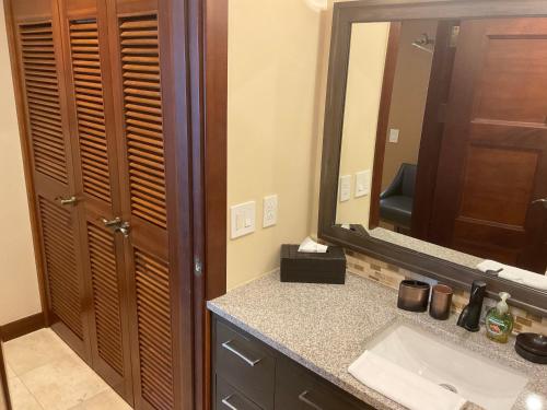 a bathroom with a sink and a large mirror at Jaco Oceanfront Condo #1119 in a Luxury Resort in Jacó