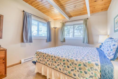 a bedroom with a bed and two windows at A Sea Breeze in Lincoln City