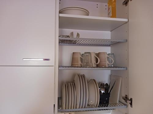 a kitchen pantry with plates and dishes on shelves at Studio Pohjola in Rovaniemi