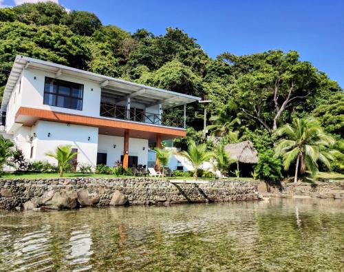 a house on the shore of a body of water at Kasakai Beachouse in Juan Gallego