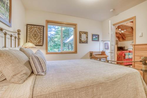 a bedroom with a large bed and a window at Guinevere's Cottage in Yachats