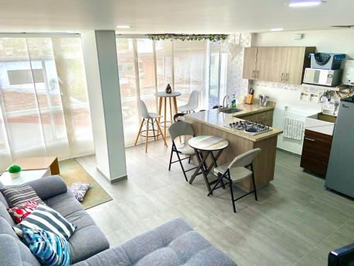 a kitchen and living room with a couch and a table at Apartamentos View, calle del Malecón frente al lago in Guatapé