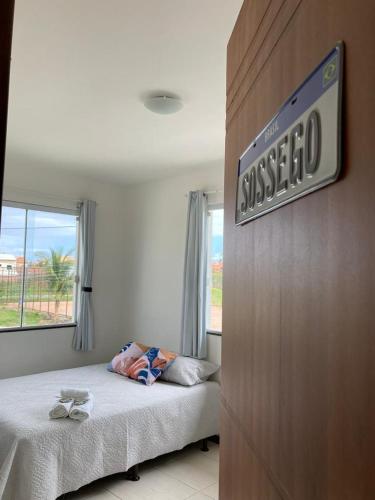 a bedroom with a bed and a sign on a wall at Casa Brisas Arembepe - arejada e aconchegante - litoral norte da Bahia - WiFi in Arembepe