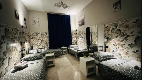 a room with two beds and two tables in it at Soha's Holiday in Rome