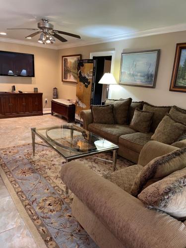 un soggiorno con divano e tavolo in vetro di Spacious Light & Bright Private Apartment a Great Falls