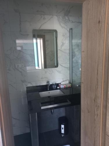 uma casa de banho com um lavatório e um espelho em Cafe Hotel centrum em Bruchsal