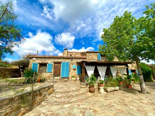 una casa con persianas azules y plantas delante de ella en Casa La Rocita, en Badajoz