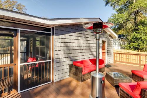 a screened in porch with a red couch and a chair at Step-Free Home with Fire Pit - 3 Miles to USC! in Columbia