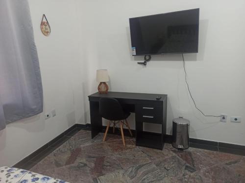 a bedroom with a desk with a television on a wall at Ótimo Apto Centro SP Tudo a Pé in Sao Paulo