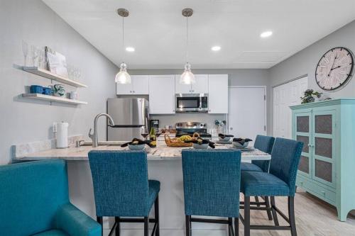 a kitchen with blue chairs and a kitchen island with a counter at Downtown Dunedin Gem, Fully Renovated #2 in Dunedin
