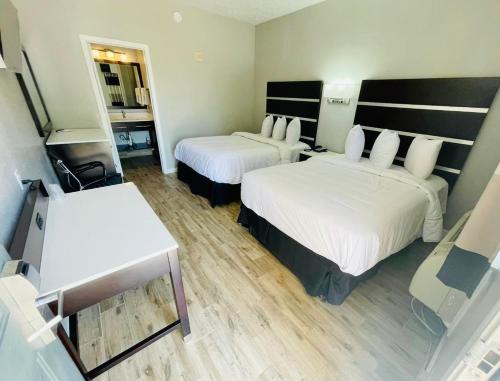 Habitación de hotel con 2 camas y TV en Americas Best Value Inn Arlington, en Arlington