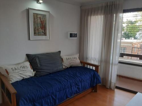 1 dormitorio con cama con sábanas azules y ventana en Mendoza Andes view en Mendoza
