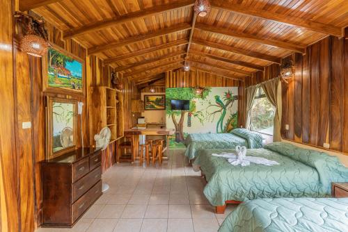 a room with four beds and a table and chairs at Monteverde Villa Lodge in Monteverde Costa Rica
