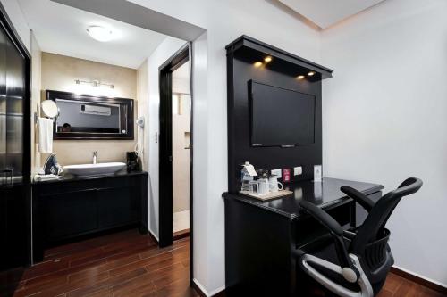 a bathroom with a black chair and a sink at Best Western Plus San Jorge in Ciudad Obregón