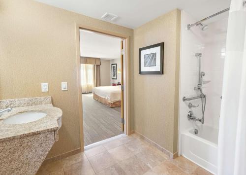 ein Bad mit einem Waschbecken und ein Bett in einem Zimmer in der Unterkunft Hampton Inn Nashua in Nashua