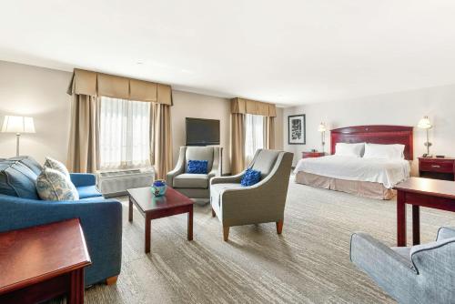 ナシュアにあるHampton Inn Nashuaのベッドと家具が備わる広いホテルルームです。