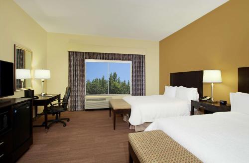 a hotel room with two beds and a desk and a window at Hampton Inn Winfield in Tucker