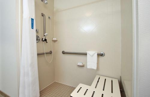 a bathroom with a shower and a toilet with a bench at Hampton Inn Winfield in Tucker
