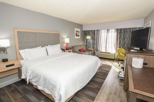 een hotelkamer met een bed en een flatscreen-tv bij Hampton Inn Jacksonville - East Regency Square in Jacksonville