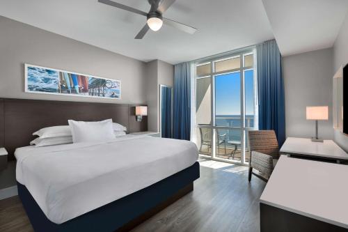 a bedroom with a large bed and a large window at Hilton Grand Vacations Club Ocean 22 Myrtle Beach in Myrtle Beach