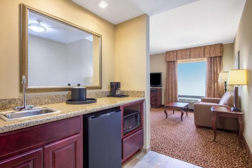 um quarto de hotel com um lavatório e uma sala de estar em Hampton Inn & Suites Oklahoma City - South em Oklahoma City