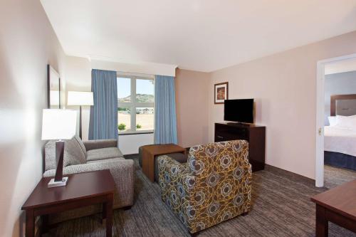 Cordelia JunctionにあるHomewood Suites by Hilton Fairfield-Napa Valley Areaのソファ、椅子、ベッドが備わるホテルルームです。