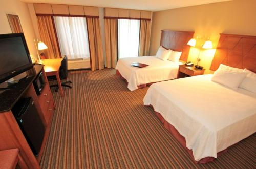 a hotel room with two beds and a flat screen tv at Hampton Inn Hampton-Newport News in Hampton