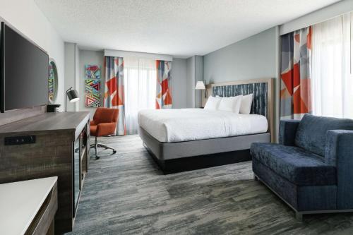 a hotel room with a bed and a couch at Hampton Inn & Suites Tampa Ybor City Downtown in Tampa