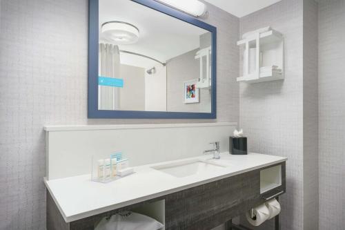a bathroom with a sink and a mirror at Hampton Inn & Suites Tampa Ybor City Downtown in Tampa