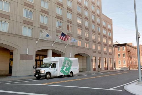 a white truck parked in front of a building at Embassy Suites Boston at Logan Airport in Boston