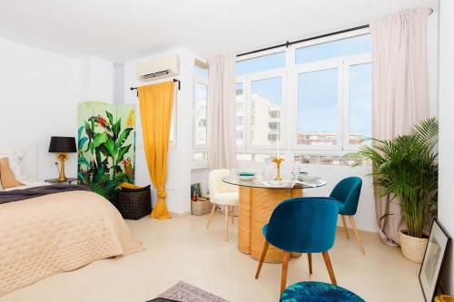 Un dormitorio con una cama y una mesa y sillas. en Palm Suite, en Torremolinos