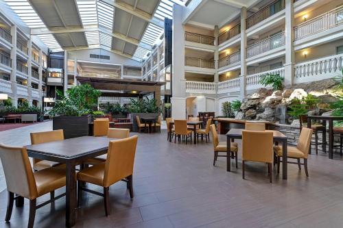 a cafeteria with tables and chairs and an aquarium at Embassy Suites by Hilton Colorado Springs in Colorado Springs