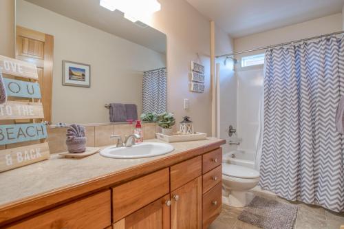 a bathroom with a sink and a toilet and a shower at Pelicans Perch Pacific City - Meredith Lodging in Pacific City