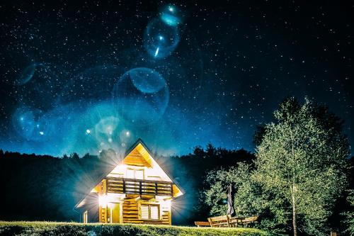 a cabin at night with the stars in the sky at Kryjówka Yetiego Domek w zaciszu Bieszczad z jacuzzi in Hoczew
