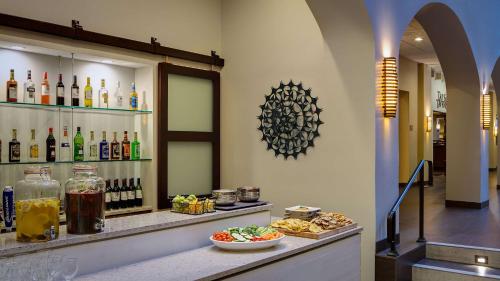 a restaurant with a bar with food and drinks at Embassy Suites by Hilton Dallas-Love Field in Dallas