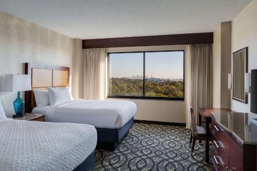 Habitación de hotel con 2 camas y ventana grande. en Embassy Suites by Hilton Dallas-Love Field, en Dallas